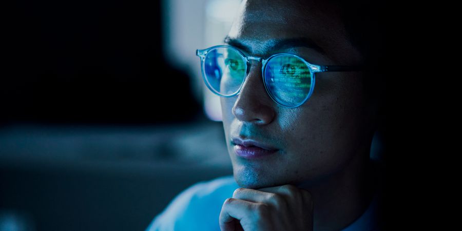 Foto von Kopf eines Mannes mit Brille die einen Bildschirm spiegelt