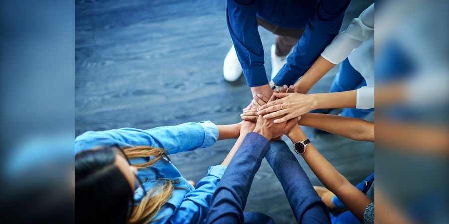 Team legt die Haende uebereinander, Sinnbild fuer Organisationsentwicklung