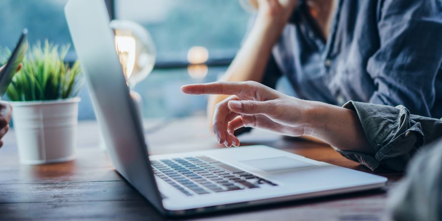 Foto von Seitenansicht eines Laptops vor Menschen im Austausch | Projektmanagement