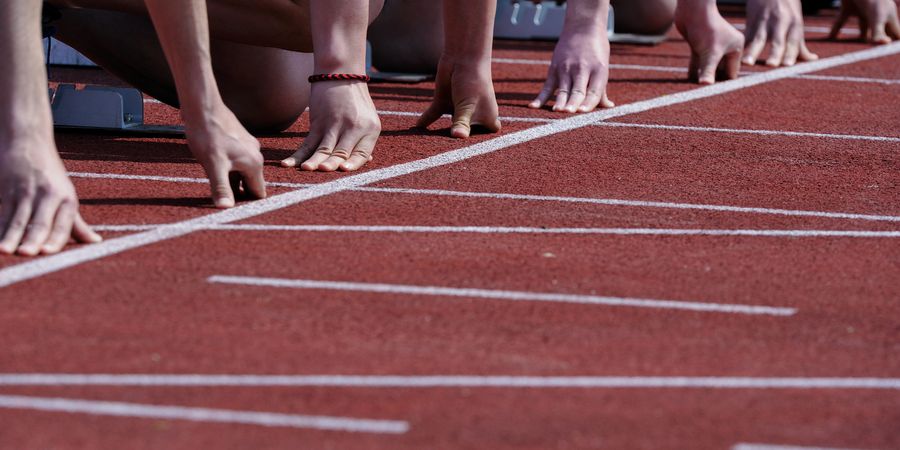 Foto Hände Läufer beim Start im Stadion | Projektmanagement IPMA & Anlaufmanagement