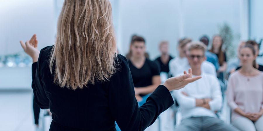 Foto aus dem Hintergrund eines Business Seminars in einem hellen Konferenzraum | Leadership, Radical Collaboration, Personalentwicklung, Managed Training Service