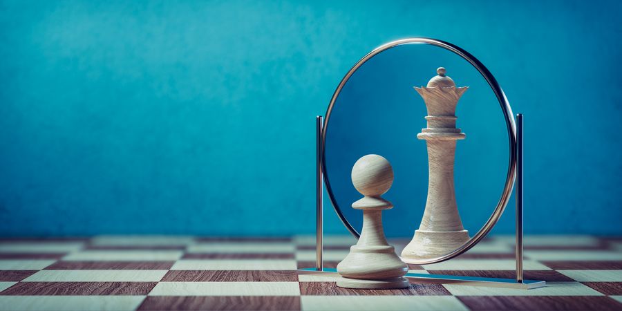Foto von Schachfigur auf Schachbrett vor Spiegel, blauer Hintergrund | Business Transformation