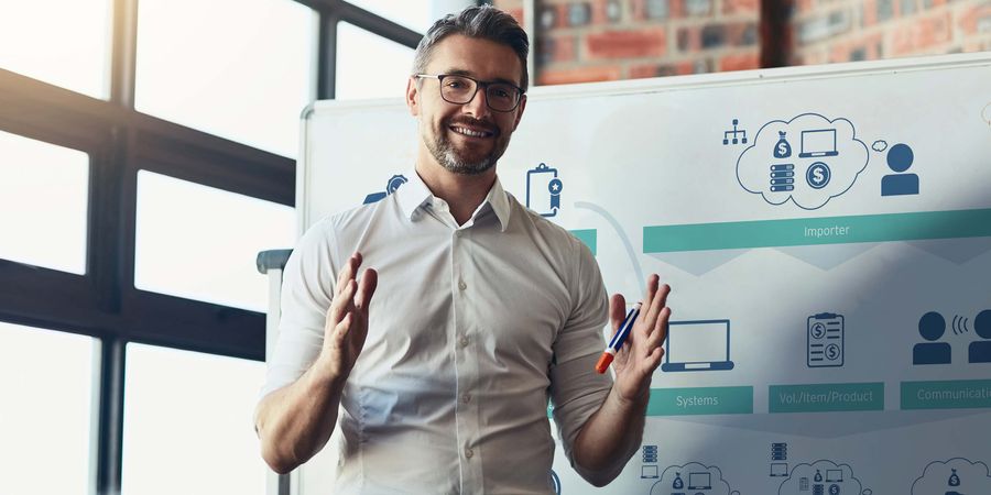 Foto eines Mannes, der etwas vor einer Tafel stehend erklärt | Projekte